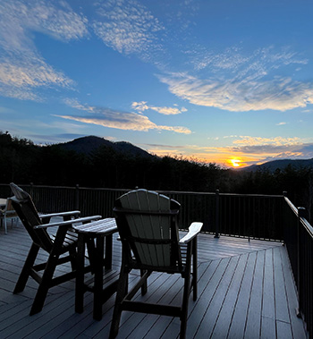 adirondack chairs strategically facing the beautiful gold sunset in an cerulian sky on a wide deck