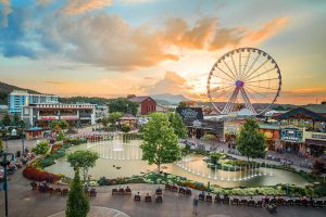 overhead shot of ferris wheel and large fountain surrounded by boutique shops in downtown pigeon forge.
