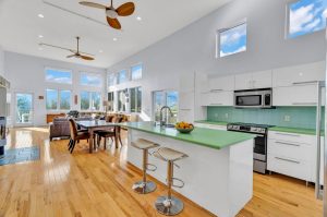 natural light streams effortlessly through the open floorplan of the great room that features 14' ceilings and hardwood floors