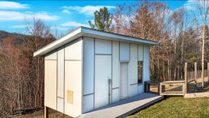 fancy modern shed with Mondrian-style Hardie siding sits at the end of a light grey walkway