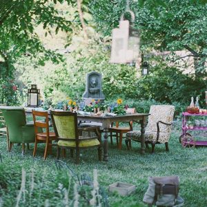 vintage furniture set up in the back yard for an outdoor meal