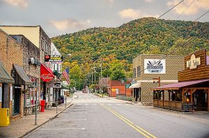 mainstreet aka The Appalachian Trail of Hot Springs, NC. Lots of little shops line the street and a mountain with golden foliage is in the background