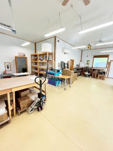 interior photo of large open room with 12' tall ceilings, natural wood trim and polished tan floors