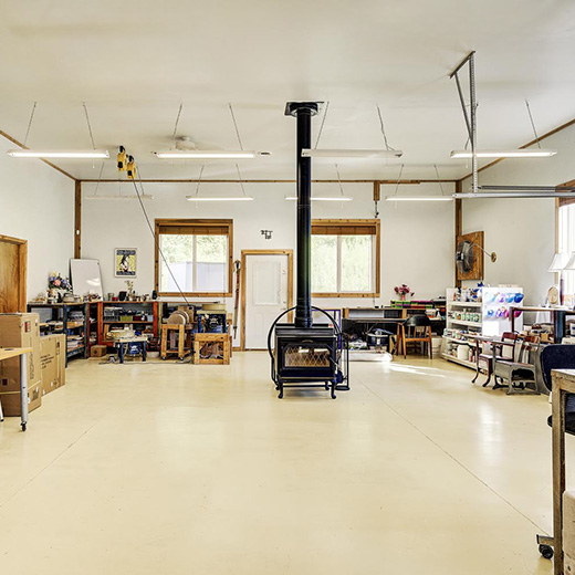 bright white studio space has a large wood stove in the middle