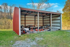 large timberframe polebarn with three open bays and walls on the three other sides