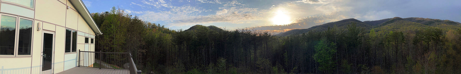 wide panorama view of mountains from the end of an elevated deck