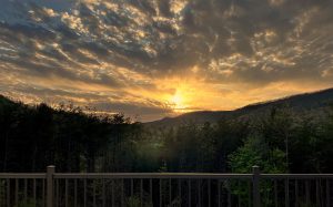 dramatic gold and orange sunset behind the mountains taken from the deck